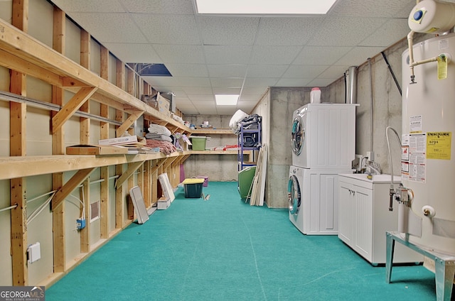 basement featuring stacked washer and dryer, a paneled ceiling, carpet flooring, and gas water heater