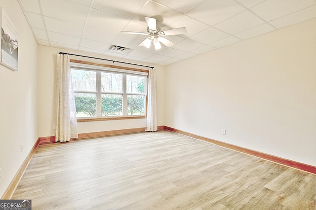 spare room with visible vents, light wood-style flooring, and a drop ceiling