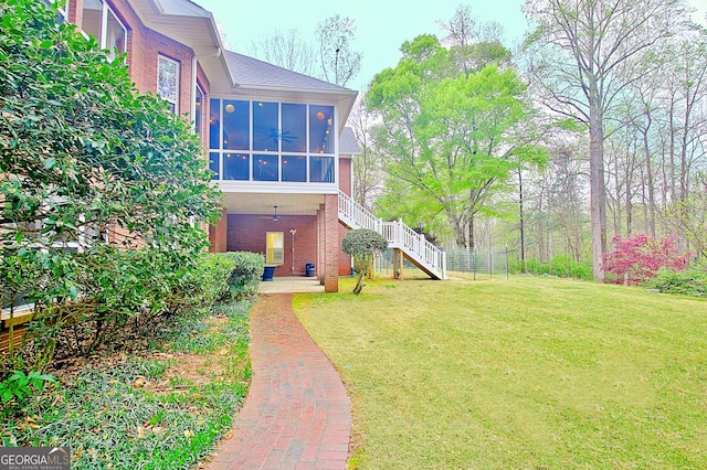 view of yard featuring stairway and a sunroom