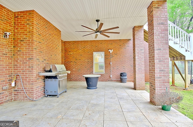 view of patio featuring area for grilling, ceiling fan, and stairway