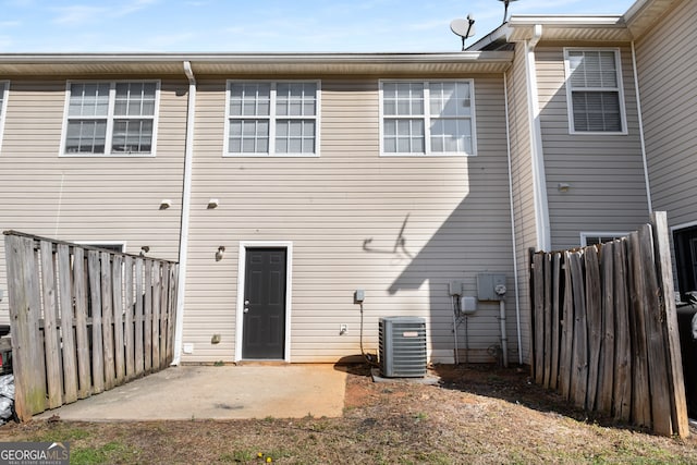 back of house with central air condition unit, fence, and a patio