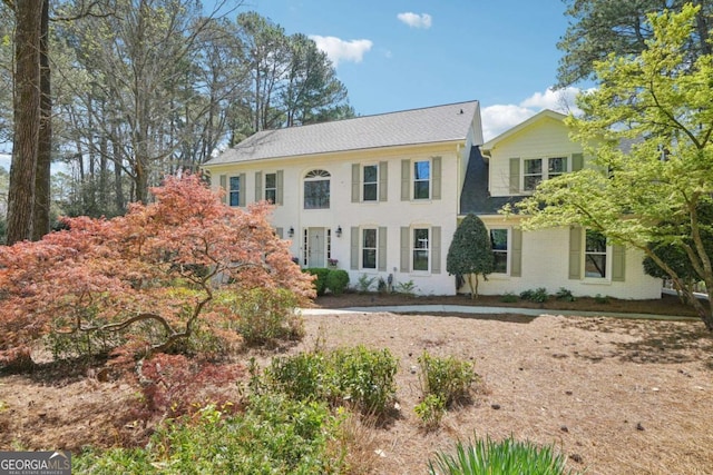 colonial home with roof with shingles