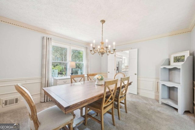 dining room with a textured ceiling, visible vents, an inviting chandelier, and light colored carpet