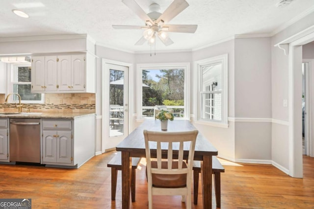 dining room with crown molding, light wood-style flooring, and ceiling fan