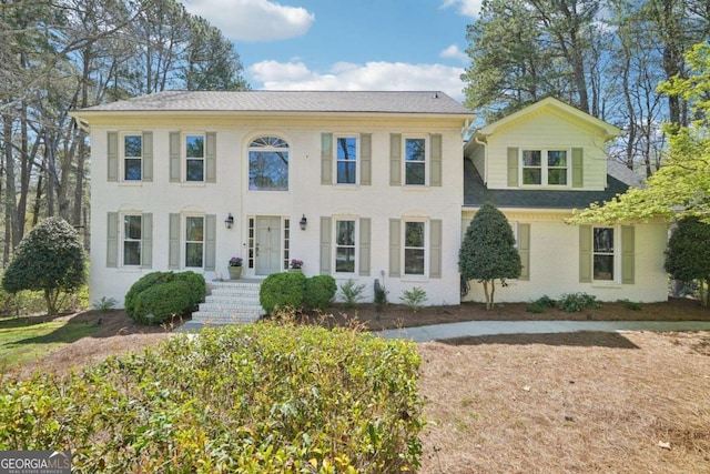 colonial inspired home with brick siding