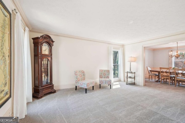 sitting room featuring baseboards, ornamental molding, a chandelier, and carpet