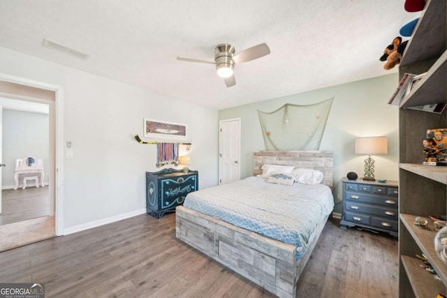 bedroom with baseboards, visible vents, ceiling fan, and wood finished floors