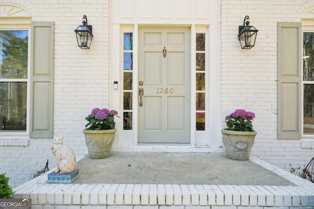 view of exterior entry with brick siding