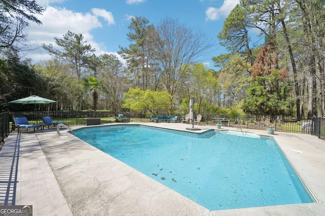 view of swimming pool with a patio area, fence, and a fenced in pool