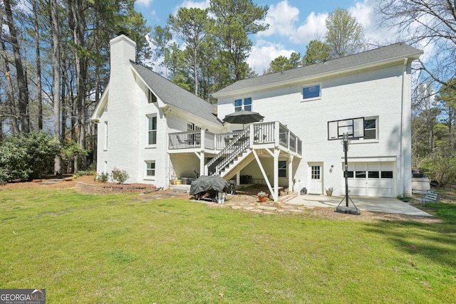 rear view of property featuring stairs, an attached garage, a lawn, a deck, and a chimney