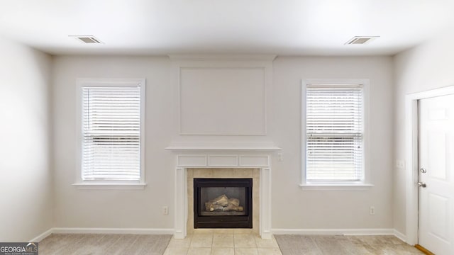 unfurnished living room with baseboards, a fireplace, and visible vents