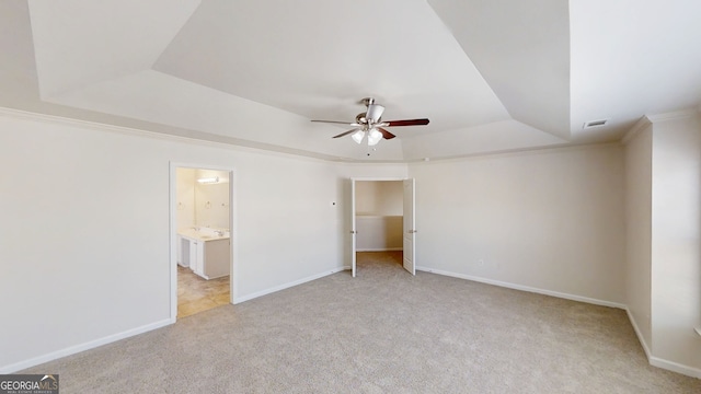 unfurnished bedroom featuring a tray ceiling, baseboards, visible vents, and carpet flooring