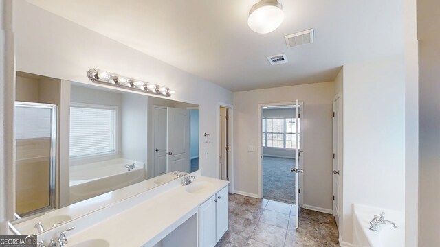 full bathroom with double vanity, a sink, visible vents, and a bath