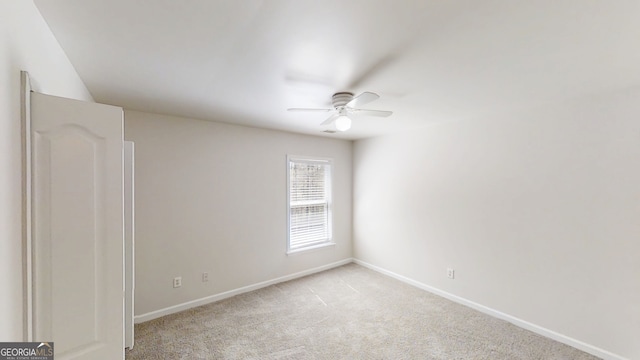 unfurnished room with baseboards, a ceiling fan, and light colored carpet