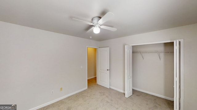 unfurnished bedroom featuring baseboards, a closet, carpet flooring, and a ceiling fan