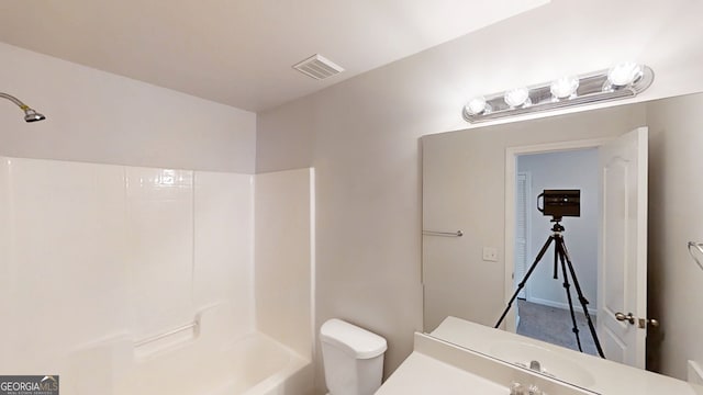 bathroom featuring visible vents, toilet, vanity, and shower / bathtub combination