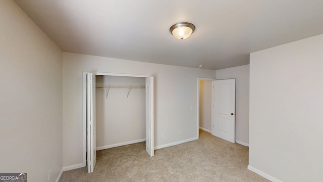 unfurnished bedroom featuring baseboards, a closet, and carpet flooring