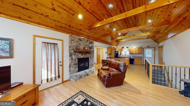 living room with lofted ceiling with beams, wood ceiling, light wood finished floors, and a fireplace