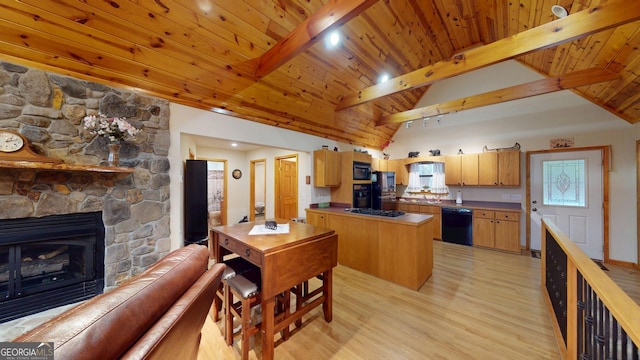 kitchen with lofted ceiling with beams, a fireplace, wooden ceiling, light wood-type flooring, and black appliances