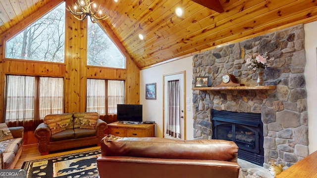 living room with a stone fireplace, wood finished floors, wooden ceiling, high vaulted ceiling, and a notable chandelier