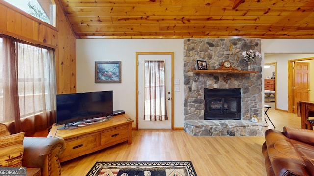 living room featuring lofted ceiling, a fireplace, baseboards, wood ceiling, and light wood finished floors