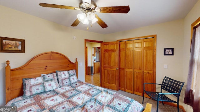 bedroom with ceiling fan, light carpet, and a closet
