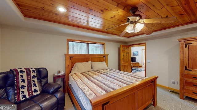 bedroom with light carpet, wood ceiling, and a raised ceiling