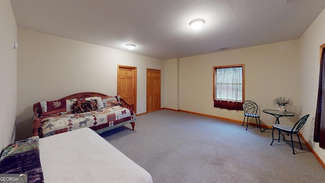carpeted bedroom with baseboards and a textured ceiling