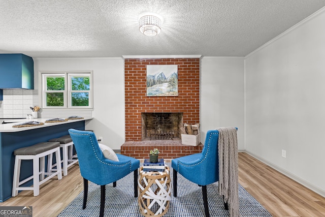 5697 Yatesville Hwy, Yatesville, GA 31097 - sitting room with ornamental molding, a brick fireplace, wood finished floors, and a textured ceiling