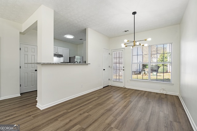 4917 Walden Lake Sq, Decatur, GA 30035 - unfurnished dining area with dark wood-style floors, a chandelier, and a textured ceiling