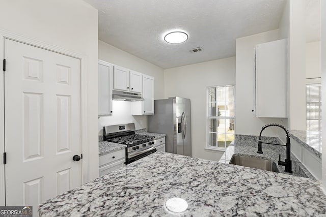 4917 Walden Lake Sq, Decatur, GA 30035 - kitchen featuring stainless steel appliances, under cabinet range hood, light stone countertops, white cabinetry, and a textured ceiling
