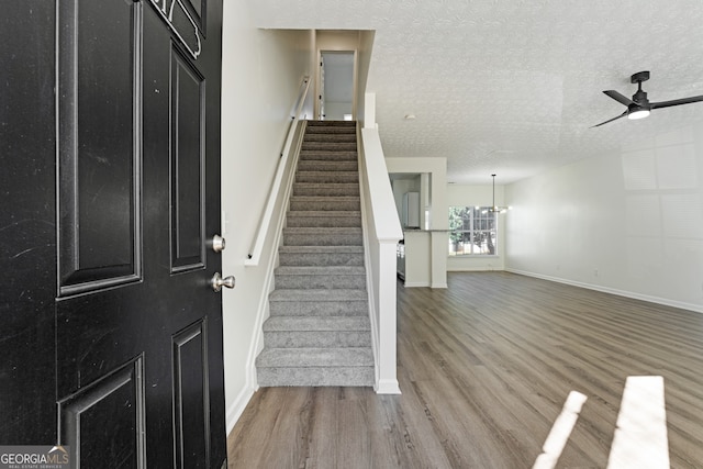 4917 Walden Lake Sq, Decatur, GA 30035 - foyer entrance with wood finished floors, a ceiling fan, stairs, a textured ceiling, and a chandelier