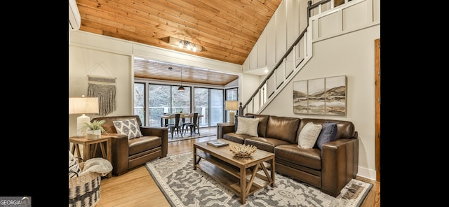 living room featuring a wall mounted AC, wooden ceiling, stairs, and light wood-type flooring