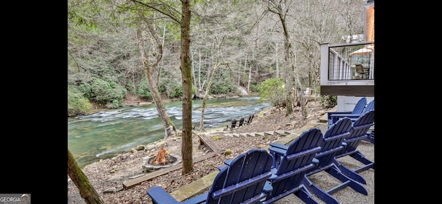 view of yard featuring a wooded view and a fire pit