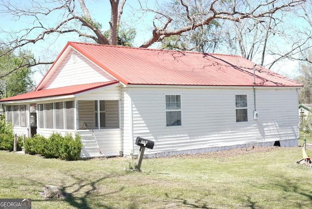 319 Isabella St, Abbeville, GA 31001 - view of home's exterior with a sunroom, a yard, and a metal roof