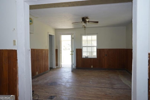 319 Isabella St, Abbeville, GA 31001 - unfurnished room with a wainscoted wall, wood walls, ceiling fan, and hardwood / wood-style floors