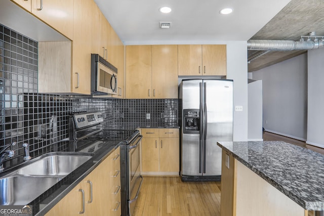 943 Peachtree St NE Unit 1003, Atlanta, GA 30309 - kitchen featuring appliances with stainless steel finishes, light wood-type flooring, dark stone countertops, tasteful backsplash, and light brown cabinetry