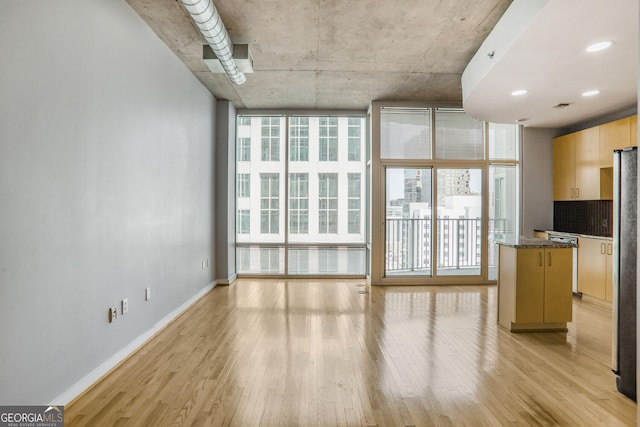 943 Peachtree St NE Unit 1003, Atlanta, GA 30309 - unfurnished living room with light wood-style flooring, healthy amount of natural light, and a wall of windows