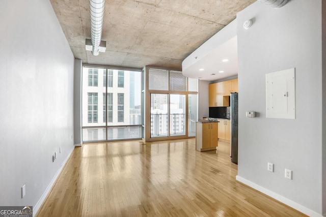 943 Peachtree St NE Unit 1003, Atlanta, GA 30309 - unfurnished living room with electric panel, light wood-style flooring, and expansive windows