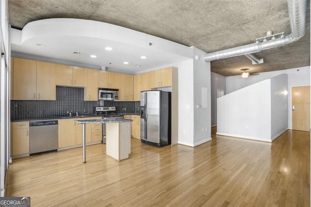 943 Peachtree St NE Unit 1003, Atlanta, GA 30309 - kitchen featuring appliances with stainless steel finishes, light brown cabinets, light wood-type flooring, open floor plan, and tasteful backsplash