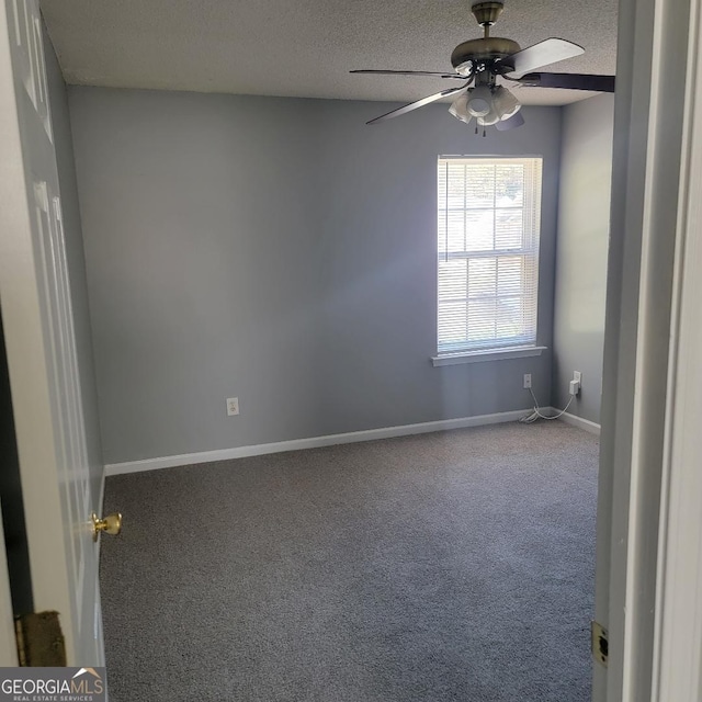 carpeted empty room with a textured ceiling, ceiling fan, and baseboards