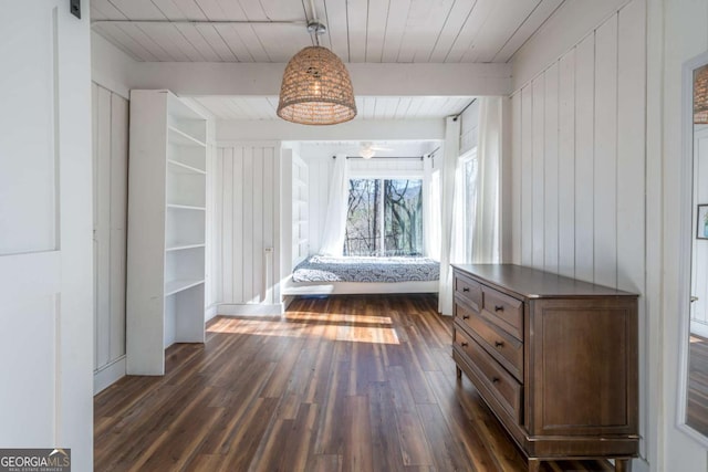 unfurnished bedroom with dark wood-style flooring, wooden walls, wooden ceiling, and beam ceiling