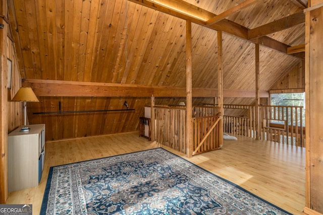 bonus room featuring wood walls, vaulted ceiling with beams, and wood finished floors