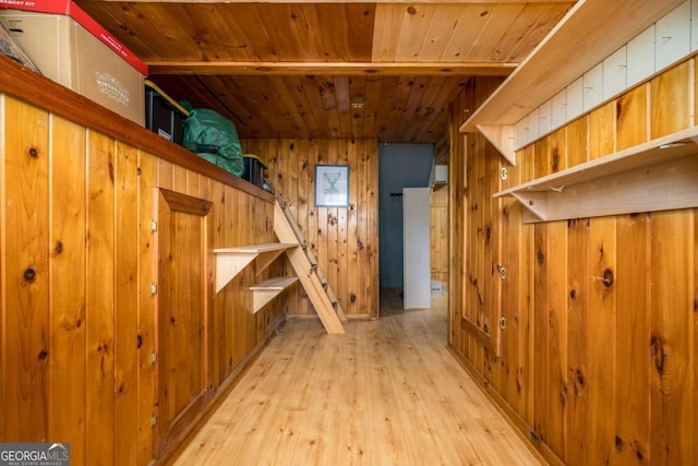 bonus room with wooden walls, light wood-style floors, and wooden ceiling
