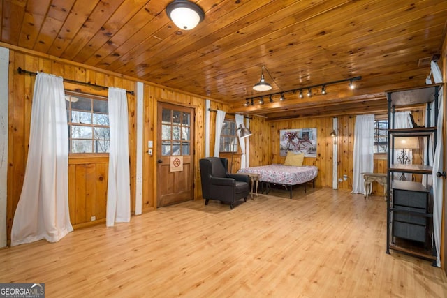 bedroom with wooden walls, wood finished floors, and wooden ceiling