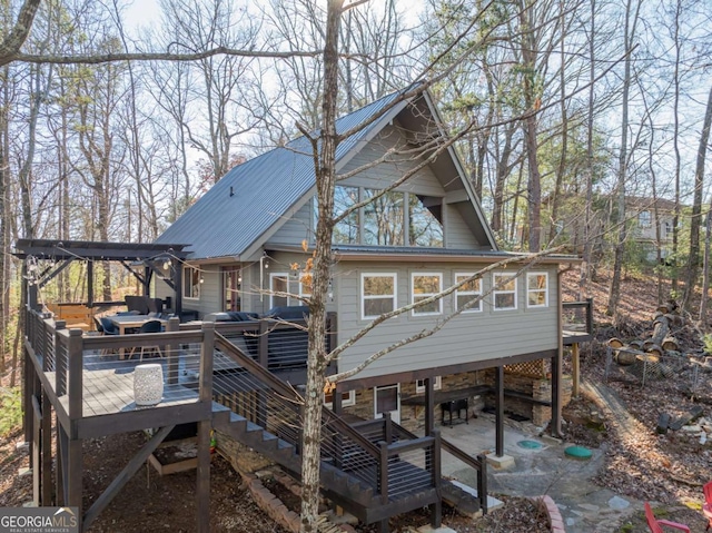 back of house featuring metal roof, an outdoor hangout area, a deck, and stairway