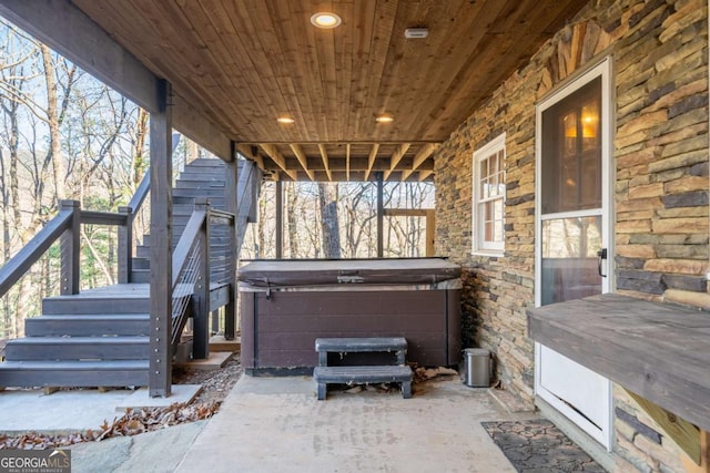 view of patio with stairway and a hot tub