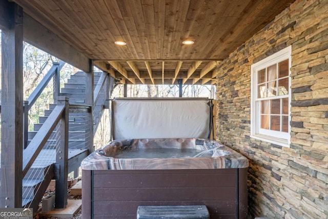 view of patio / terrace featuring a hot tub and stairs