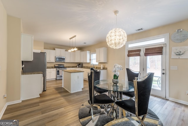 3450 Long Lake Dr, Douglasville, GA 30135 - dining space featuring baseboards, light wood-style floors, a notable chandelier, and visible vents