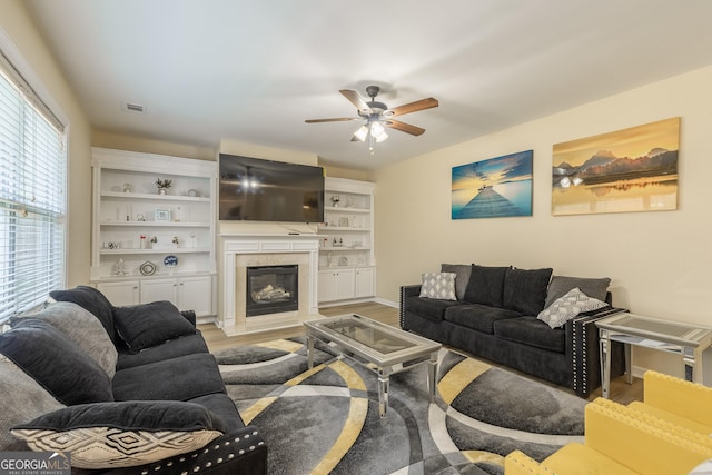 3450 Long Lake Dr, Douglasville, GA 30135 - living area with a premium fireplace, visible vents, ceiling fan, and light wood-style flooring